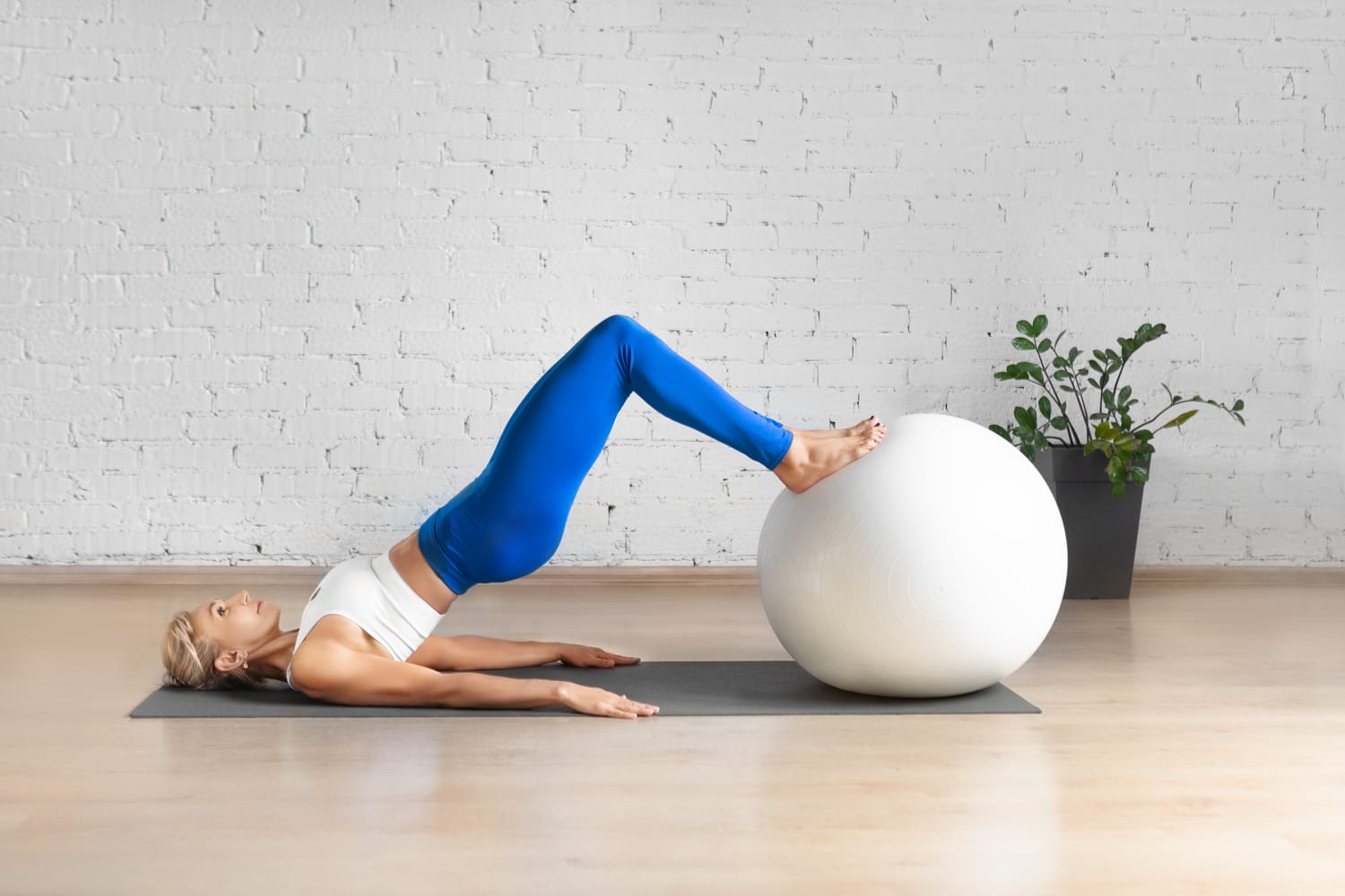 Frau trainiert den Beckenboden mit einem Fitnessball